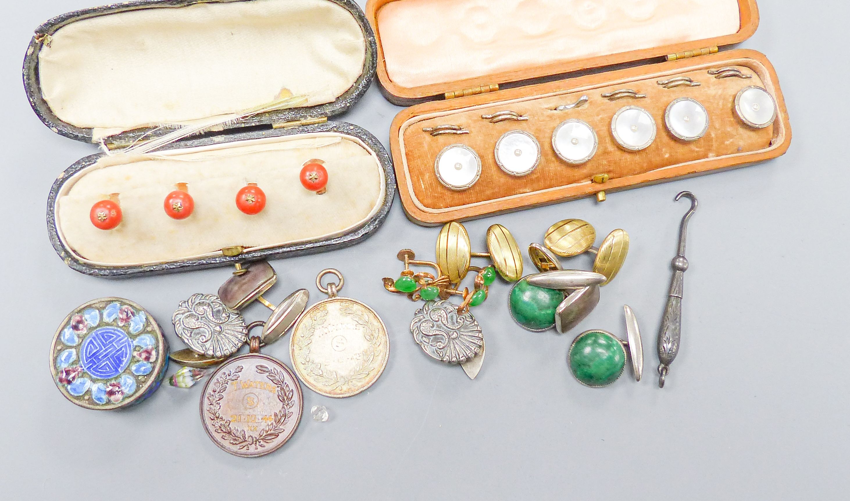 A set of four coral dress studs (cased), a set of six mother of pearl studs (cased), a pair of yellow metal cufflinks, a pair of silver cufflinks and sundry items